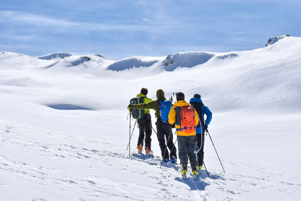 group of skiers on the way up a mountain 